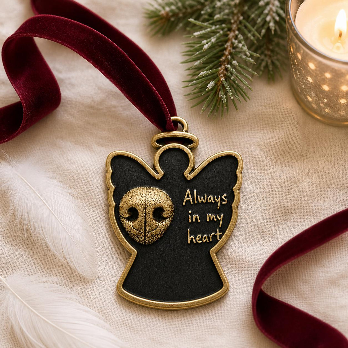 Angel nose print ornament on a fluffy white throw with a red velvet ribbon and a candle