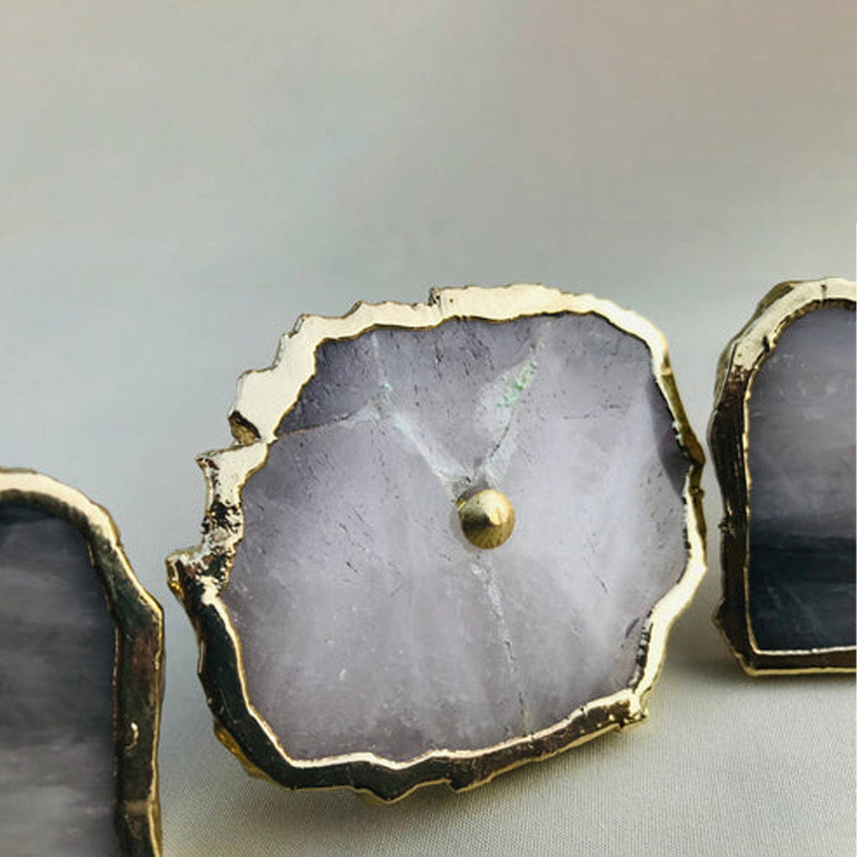 Close-up of a pale gray agate quartz slice with a gold edge