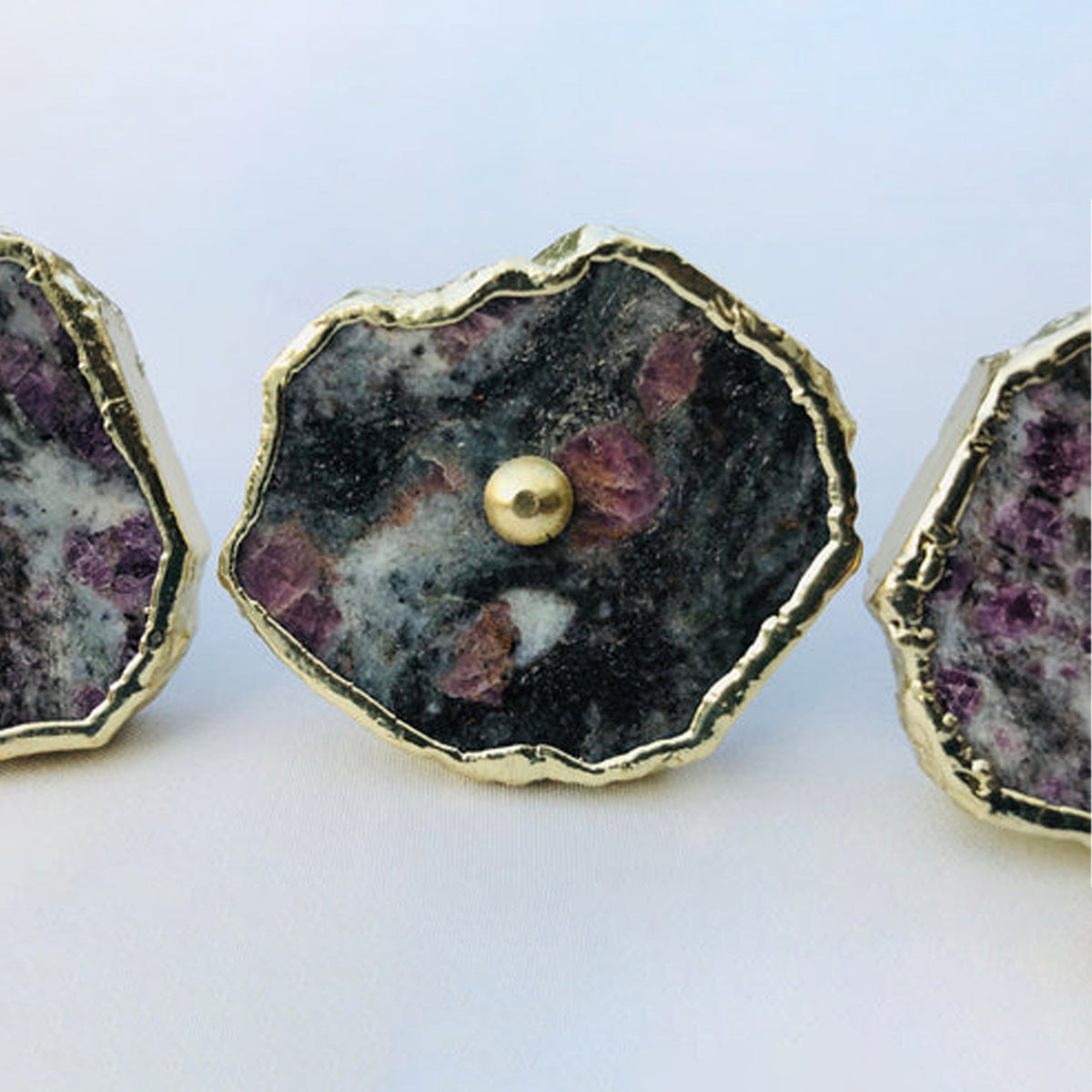 Close-up of one lepidolite slice knob, purple flecks scattered over dark stone