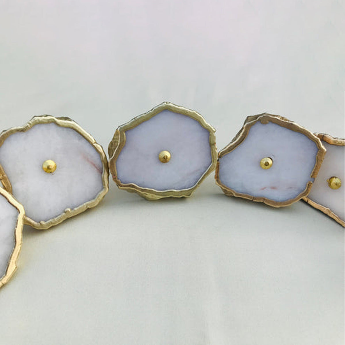 Row of milky white agate slice knobs with gold edges