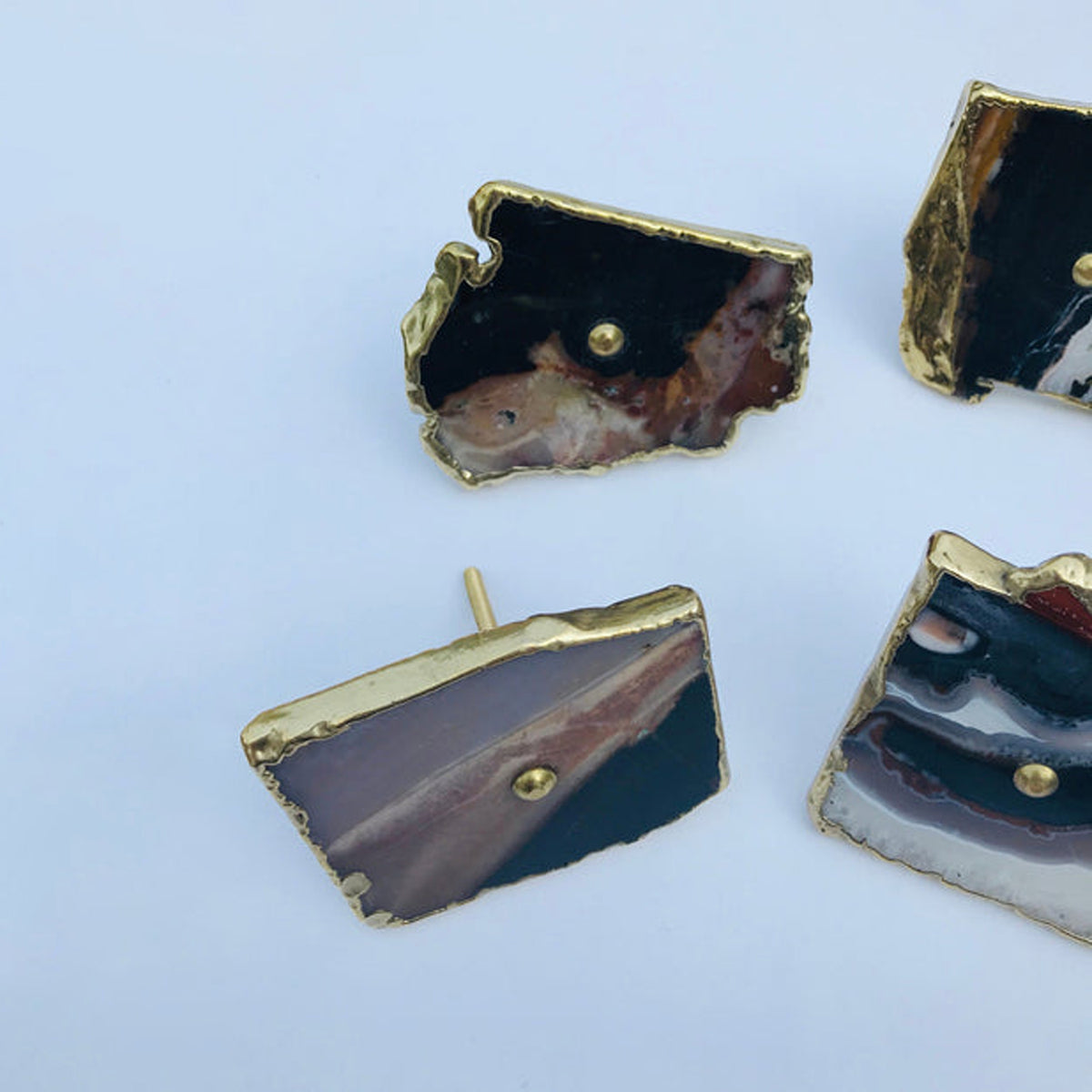 Zebra agate slice knob tipped on its side to show its post, others around it