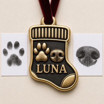 Antique brass stocking-shaped pet ornament with a raised paw print, nose print and LUNA, beside the ink print cards