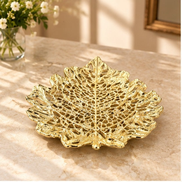 Skeleton leaf tray in gold on a marble counter with flowers