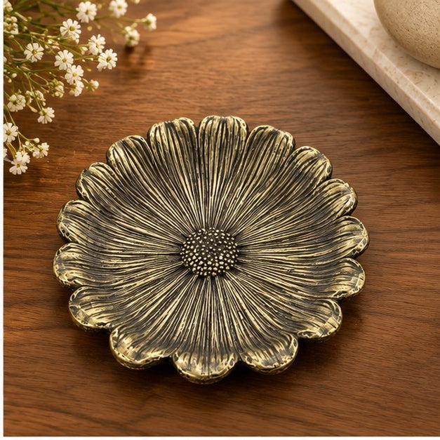 Flower dish in antique brass on a wooden table