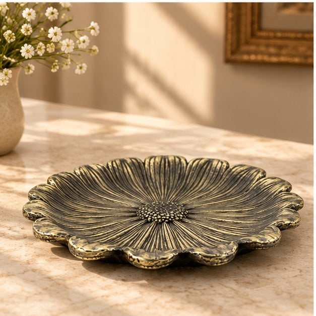 Flower dish in antique brass on a marble counter, seen at an angle