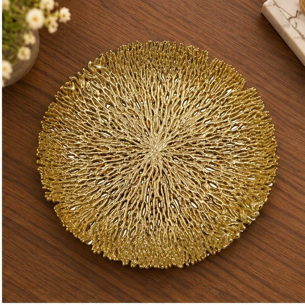 Round coral openwork tray in gold on a wooden table