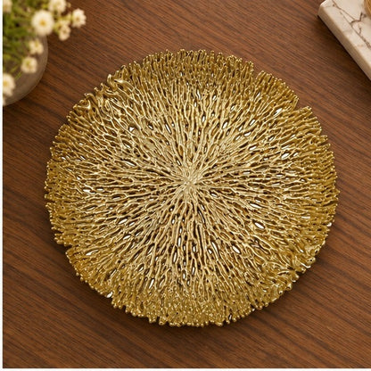 Round coral openwork tray in gold on a wooden table