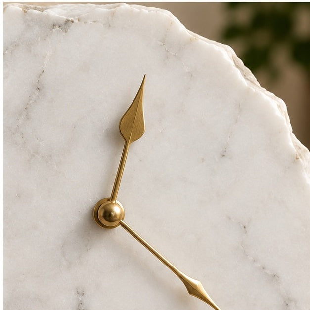 Close-up of the gold hands on the white marble desk clock