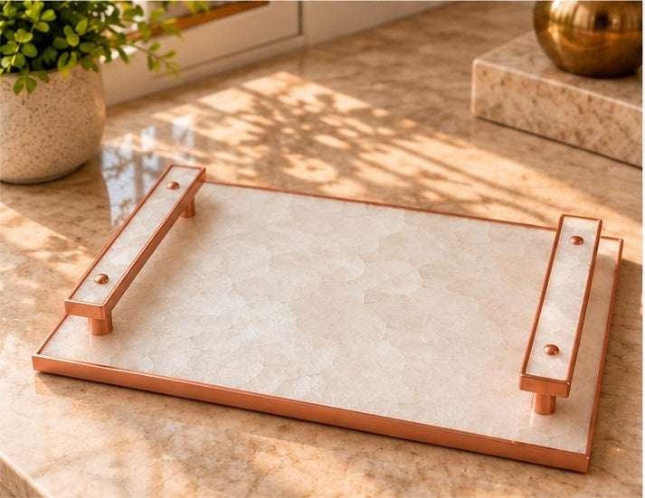 
White crystal agate tray with pale stone-inlaid bar handles in a rose gold finish, shown on a table