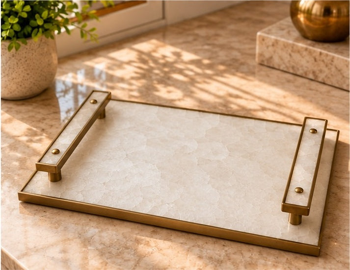 
White crystal agate tray with pale stone-inlaid bar handles in a antique brass finish, shown on a table