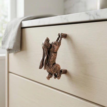 A hopping hare handle in antique copper on a drawer