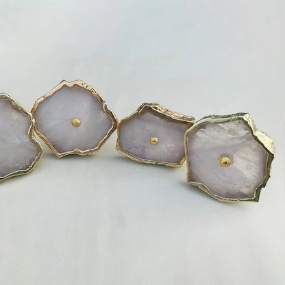 Rose quartz slice knobs in a curve, the rightmost knob tilted toward the camera