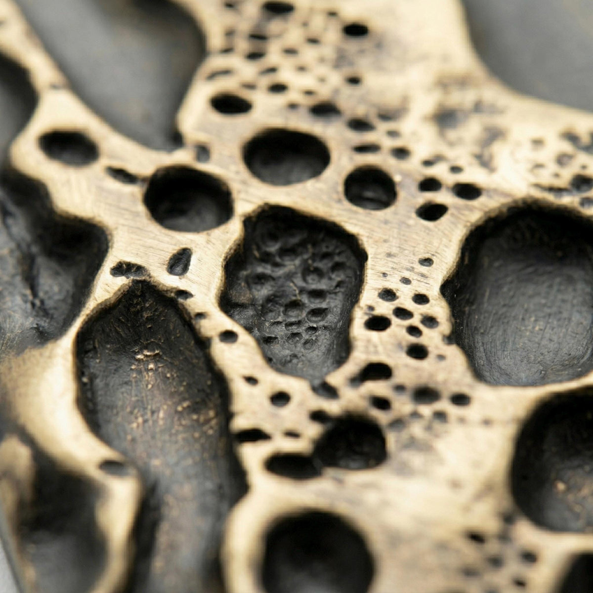 Close-up of the crater hollows and small pits in antique brass