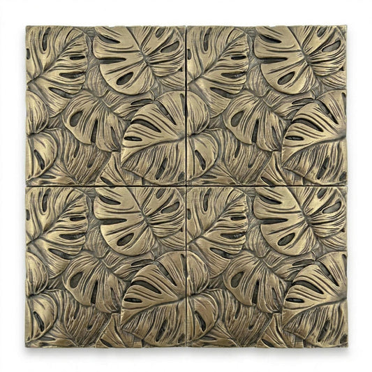 Four monstera leaf tiles in antique brass, set in a square