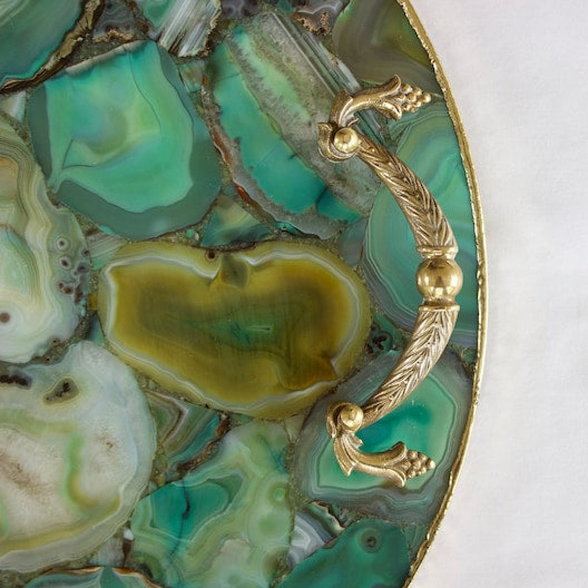 Silver finish handles on a round green agate serving tray