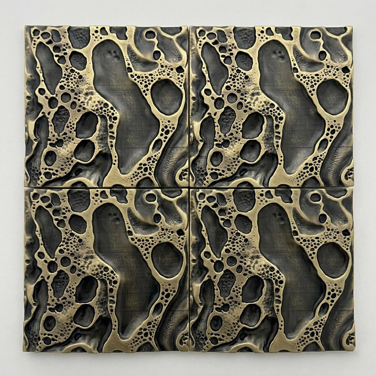 Four cosmic crater tiles in antique brass