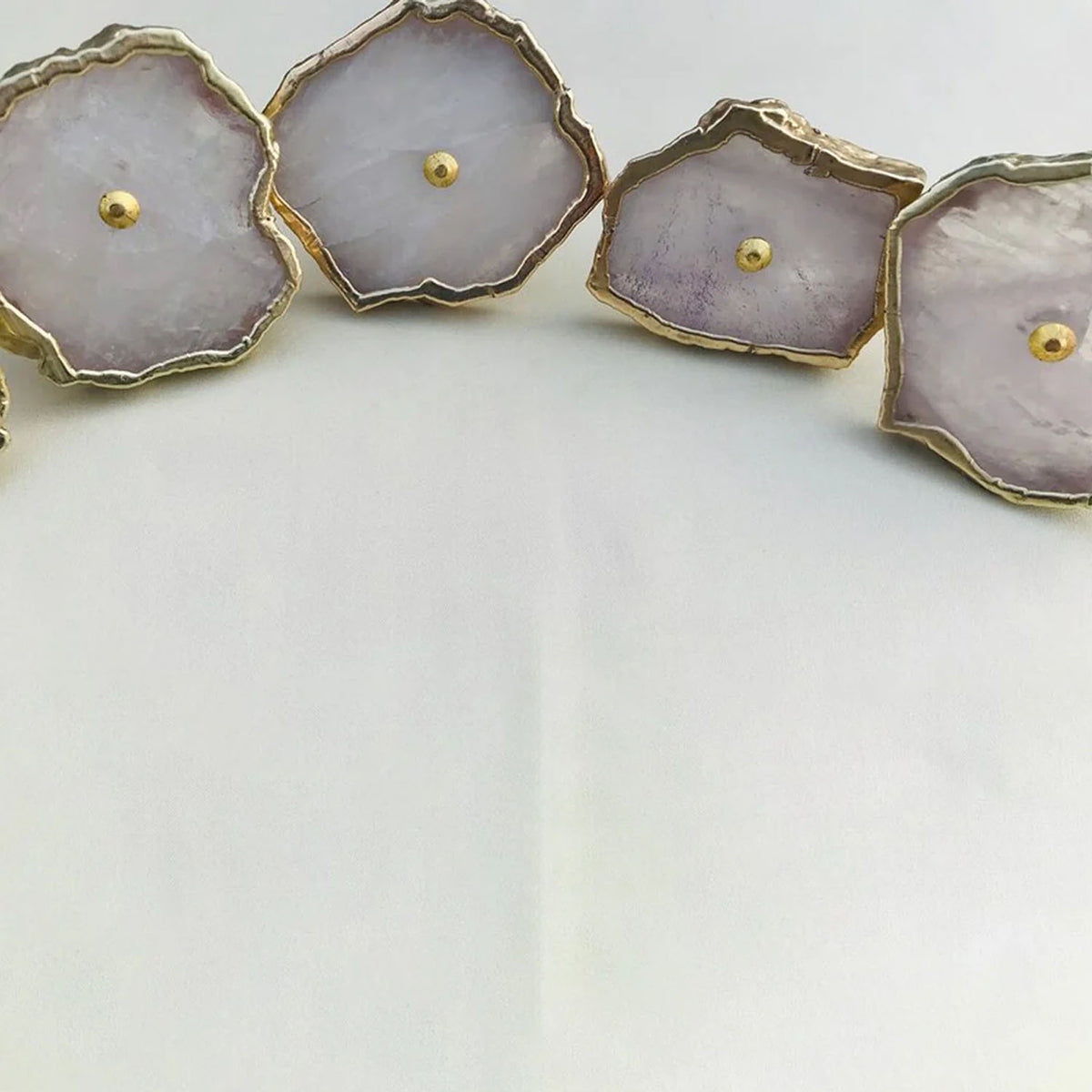 Rose quartz slice knobs in a curve, close-up
