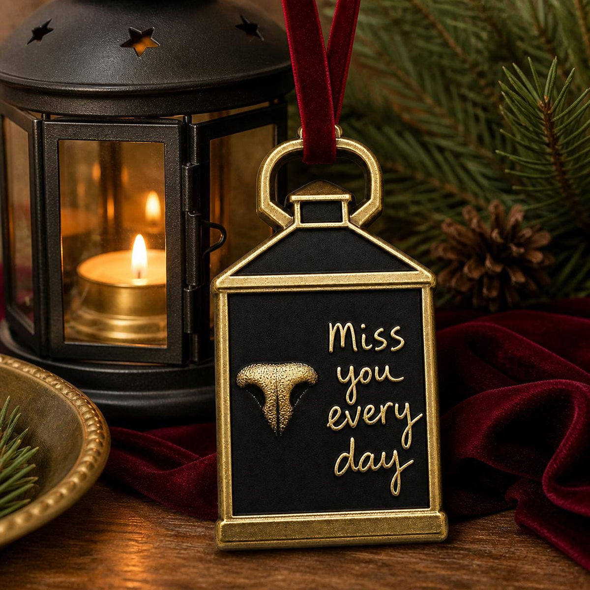 Lantern nose print ornament hanging beside a black candle lantern with a lit candle