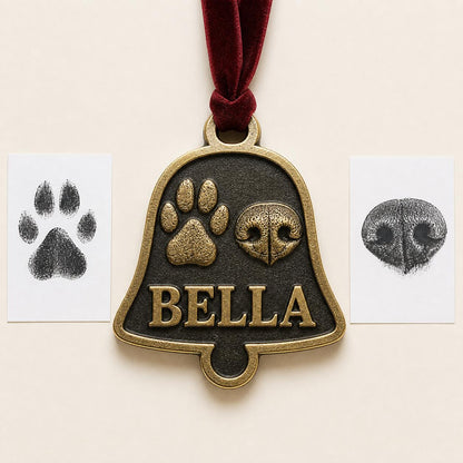 Antique brass bell-shaped pet ornament with a raised paw print, nose print and BELLA, beside the ink print cards