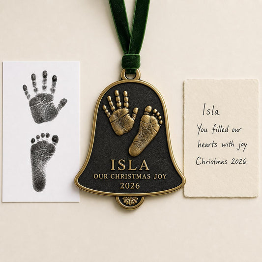 An antique brass bell-shaped baby ornament with a raised handprint and footprint