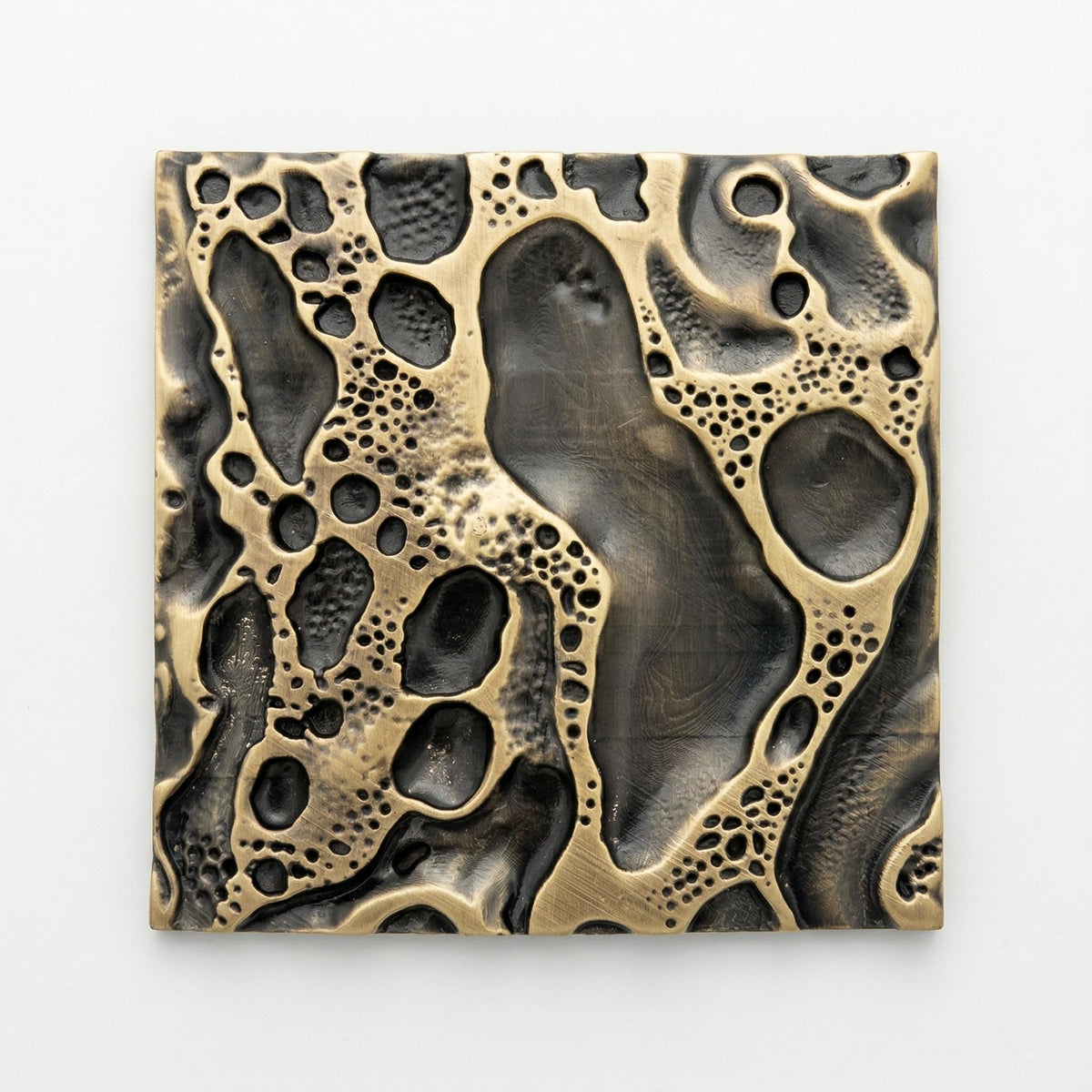 One cosmic crater tile in antique brass