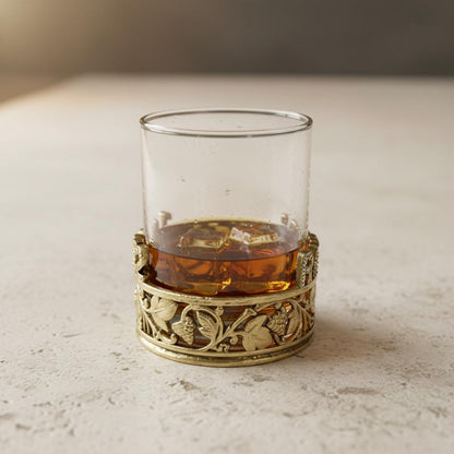 Side view of the gold vine band around a glass of whiskey on ice