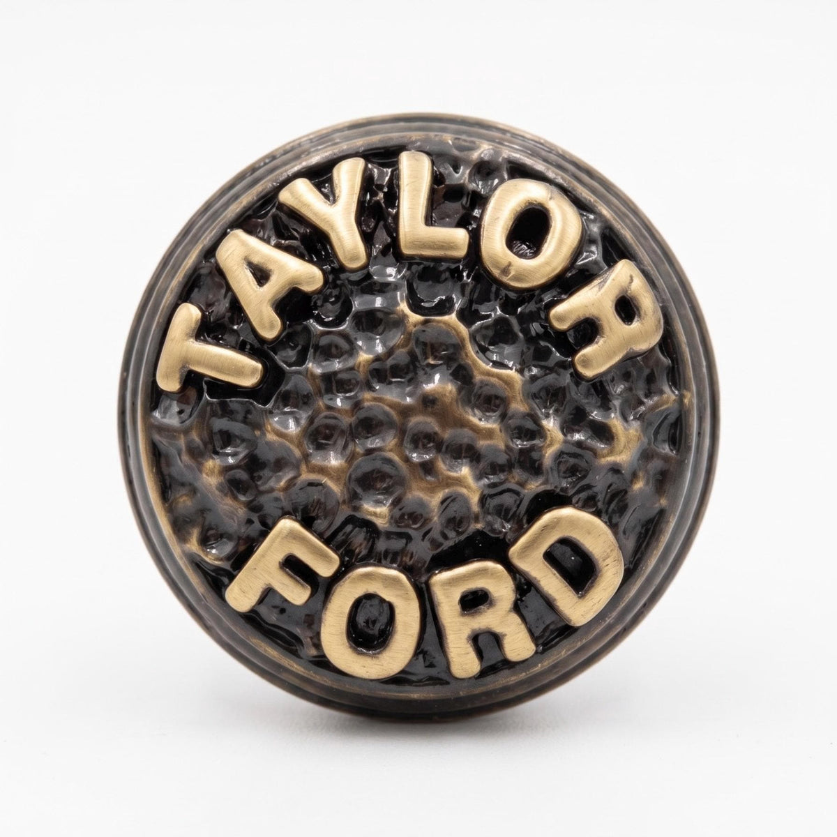 Close-up of a TAYLOR FORD knob, the raised letters on a hammered face