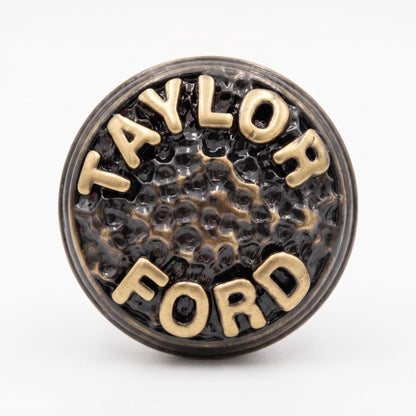 Close-up of a TAYLOR FORD knob, the raised letters on a hammered face