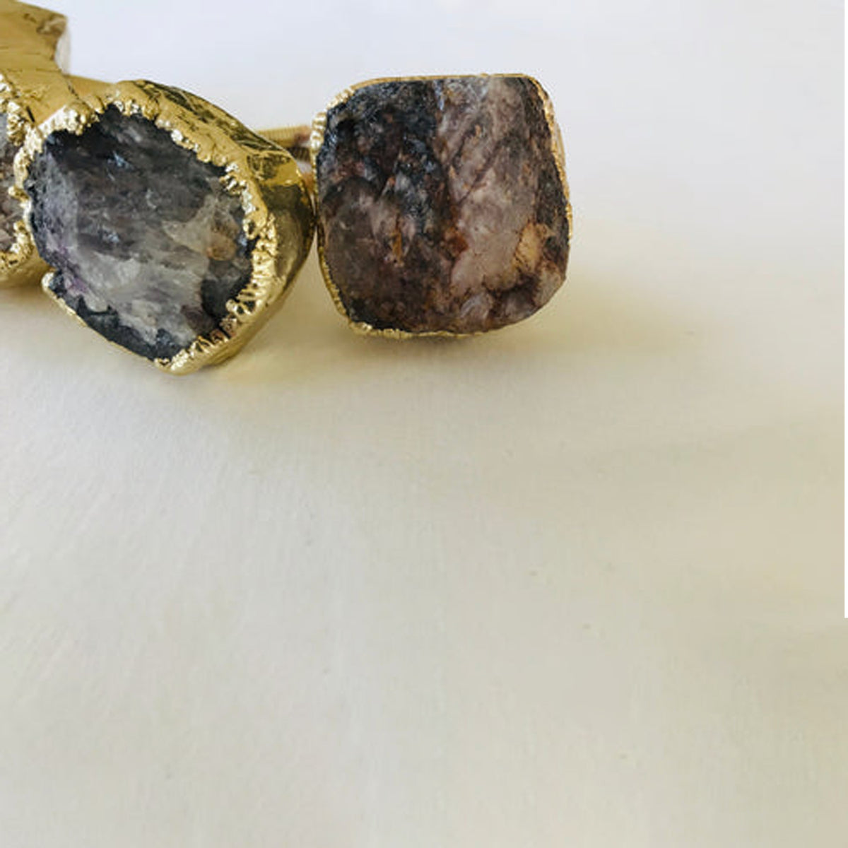 Two raw amethyst knobs at the edge of the frame, one showing its rough side