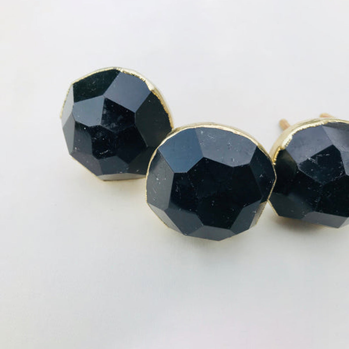 Round faceted black obsidian knob centered between two others