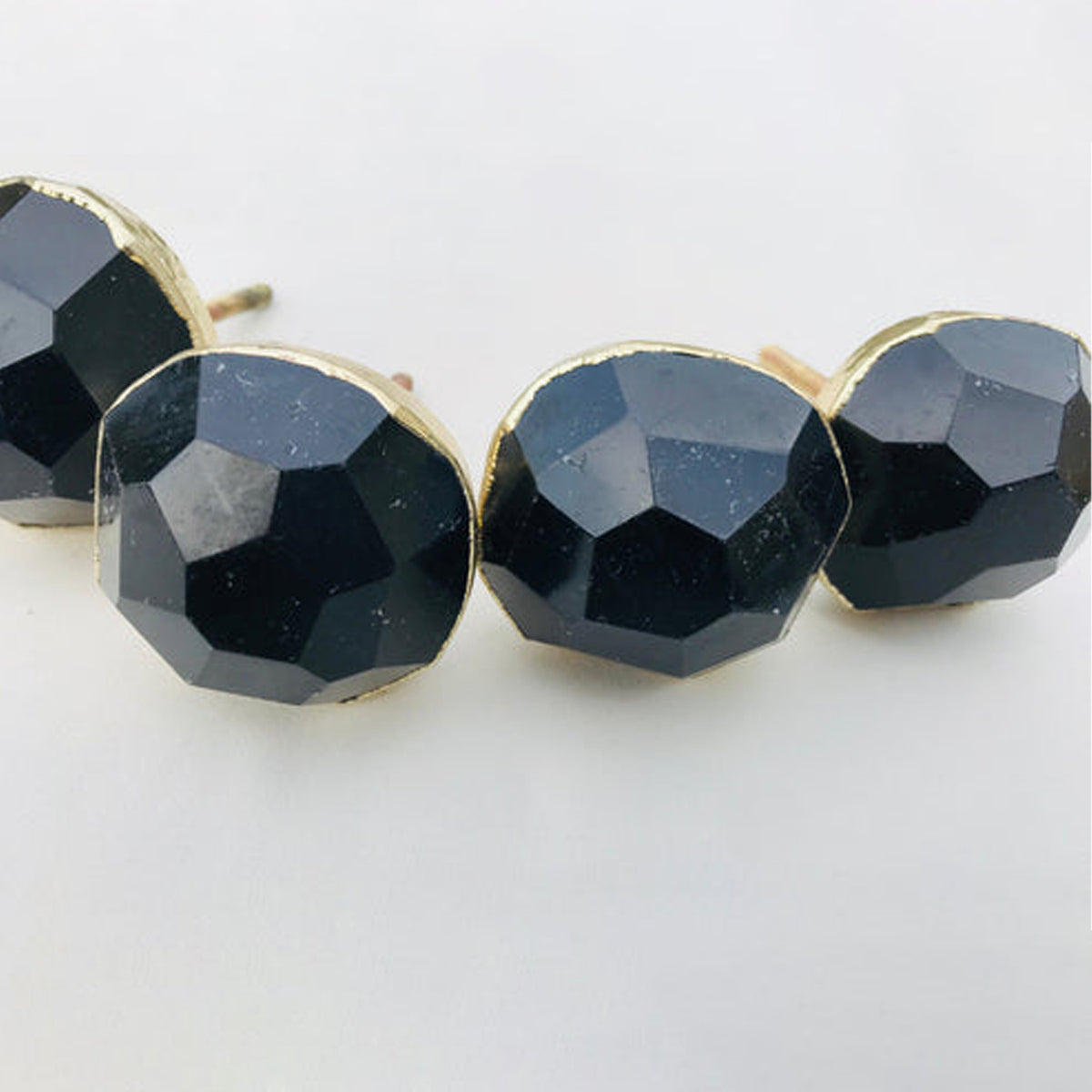 Close-up of round faceted black obsidian knobs in a row