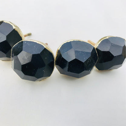 Close-up of round faceted black obsidian knobs in a row