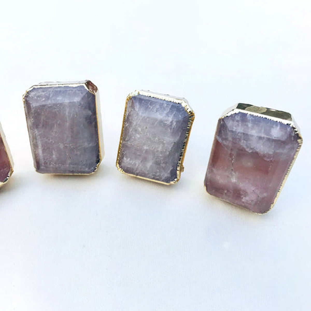 Three emerald-cut quartz knobs up close, one with a pink tint at the base
