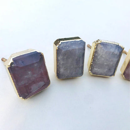 Emerald-cut quartz knobs seen from the left, the nearest one tinted pink