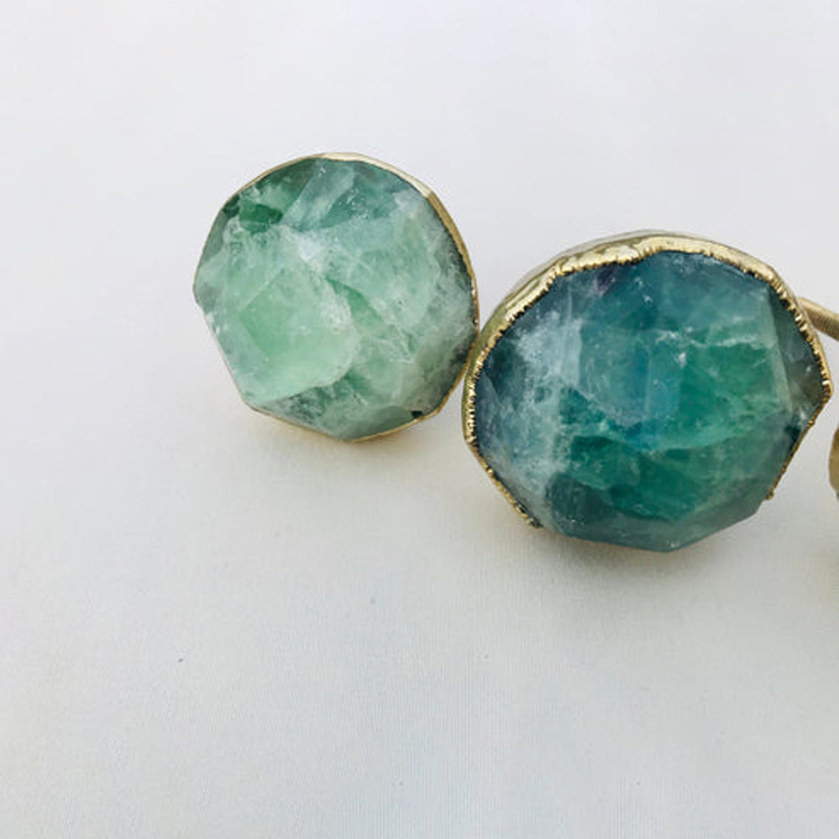 Two faceted green fluorite knobs, one pale mint and one deep green