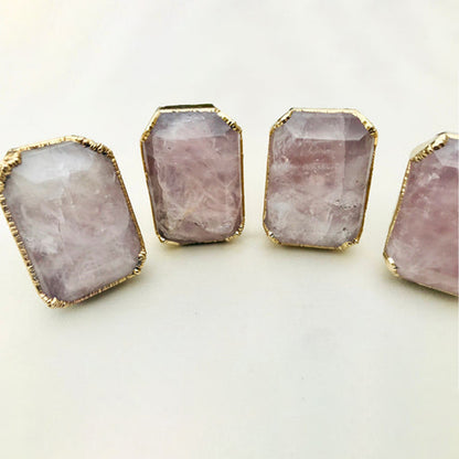 Closer view of emerald-cut rose quartz knobs in a row, pale pink with gold rims