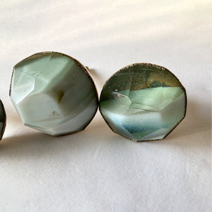 Two faceted knobs in milky white and gray-green, close-up