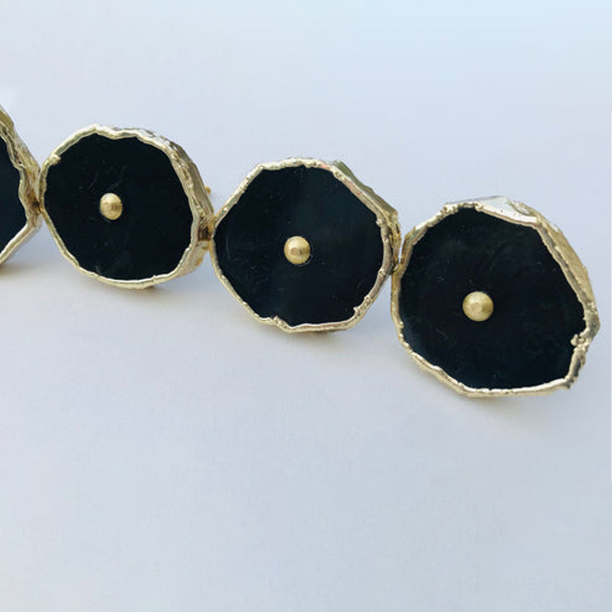 Row of black agate slice knobs with gold edges and center pins