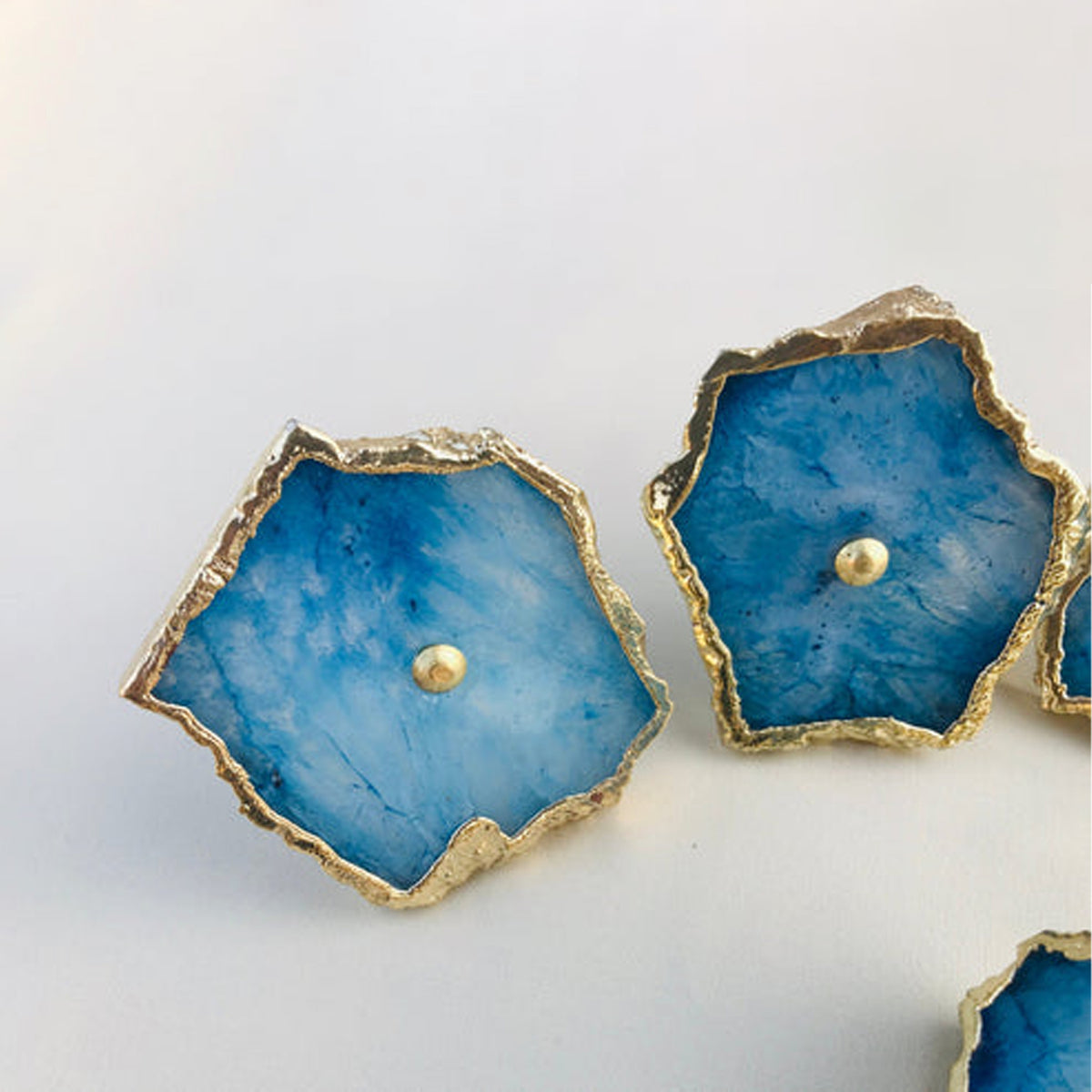 Blue agate slice knobs seen from above, each with a brass center pin