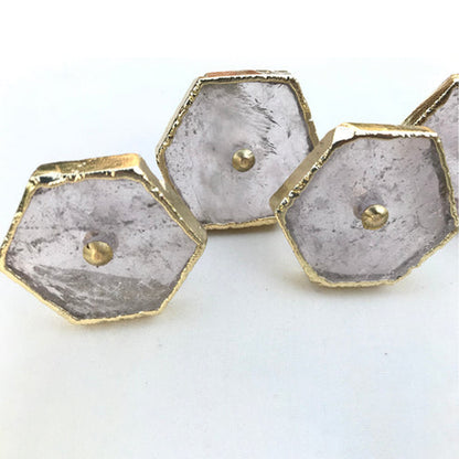 Three clear quartz hexagon knobs up close, cloudy crystal with brass center pins