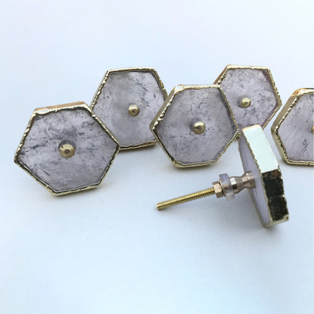Row of clear quartz hexagon knobs with one tipped forward to show its bolt