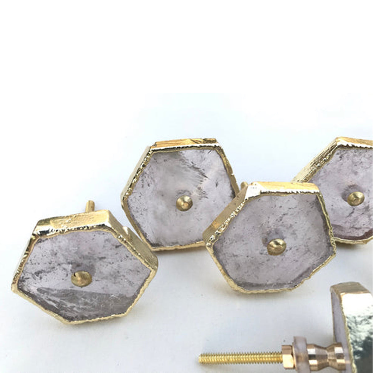 Close-up of clear quartz hexagon knobs with gold edges and center pins