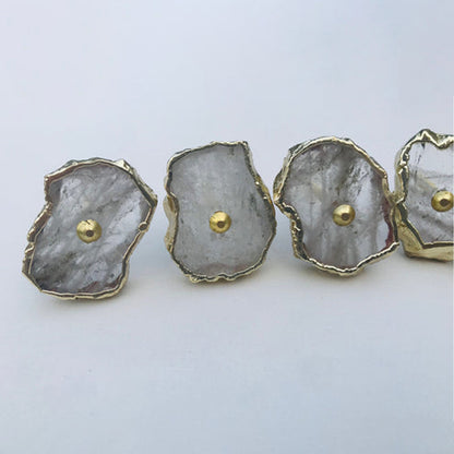 Four clear quartz slice knobs with gold rims and brass center pins