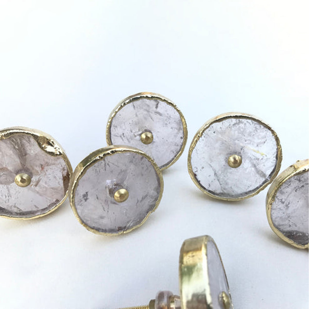 Round clear quartz knobs with gold rims, one turned on its side