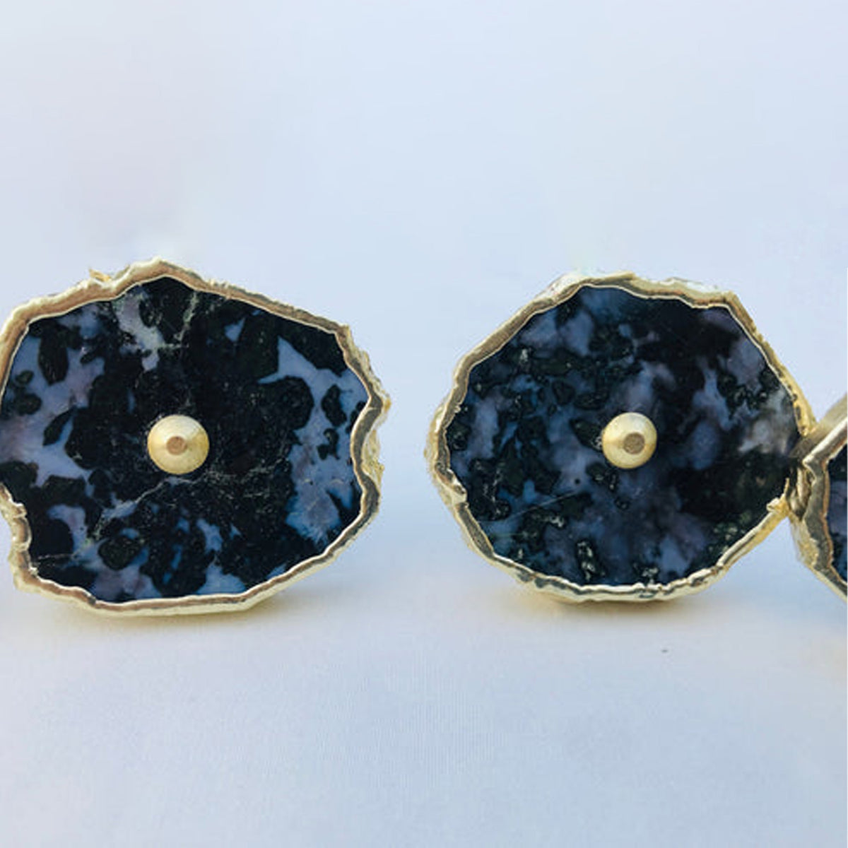 Two gabbro slice knobs side by side, mottled black and gray with center pins