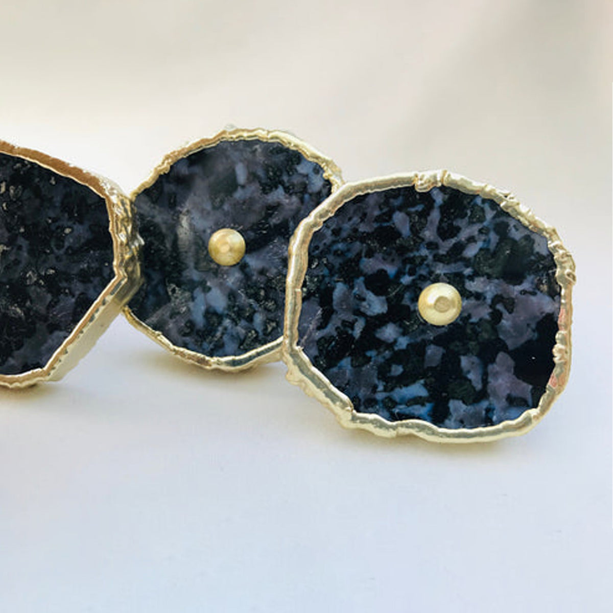 Close-up of dark speckled gabbro slice knobs with gold edges