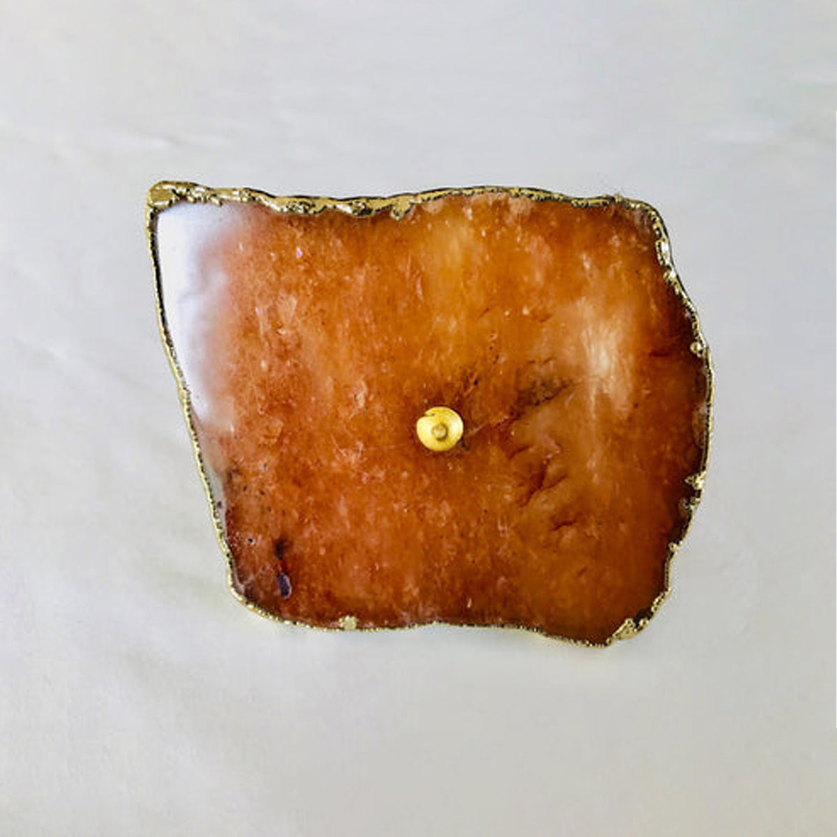 Close-up of one golden agate slice knob, amber stone with a brass center pin