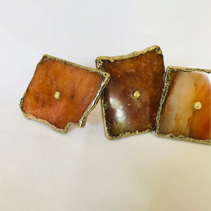 Three golden agate slice knobs in a row, amber, brown and cream tones