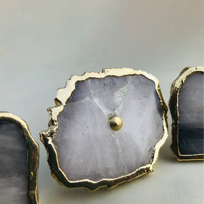 Close-up of a pale gray agate quartz slice with a gold edge