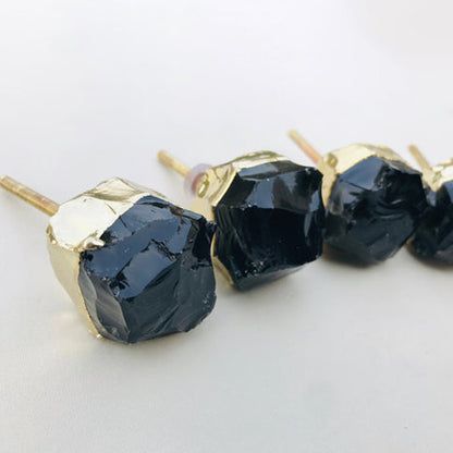 Raw black obsidian knobs with gold caps and their bolts